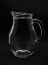 An empty glass milk jug. A glass vessel on a black background Royalty Free Stock Photo