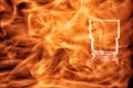 Empty glass for spirits in the fire flames. Royalty Free Stock Photo