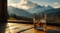 an empty glass of whisky and mountains
