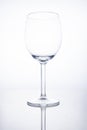 Empty glass wine goblet on white background with reflection