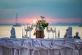 Empty glasses are on the served table. Against the backdrop of a sunset in the sea on a sandy beach Royalty Free Stock Photo