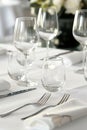Empty glasses and silverware resting on a table set with white linen Royalty Free Stock Photo