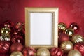 Empty Gold Frame with Christmas Ornaments on a Red Background Royalty Free Stock Photo