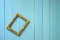 An empty golden frame hangs askew on a plank wall Royalty Free Stock Photo