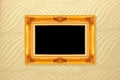 Empty golden vintage frame on wallpaper background Royalty Free Stock Photo