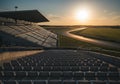 Racetrack grandstand seating at sunset overlooking the track and green fields Royalty Free Stock Photo