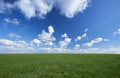 Empty grass field meadow landscape with blue sky, white clouds Royalty Free Stock Photo