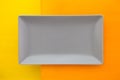 Empty gray ceramic dish on over orange and yellow wooden table Royalty Free Stock Photo