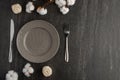 Empty gray dish with knife and fork on a slate background with a cotton branch, with copy space for your menu or recipe. Menu card Royalty Free Stock Photo