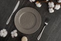 Empty gray dish with knife and fork on a slate background with a cotton branch, with copy space for your menu or recipe. Menu card Royalty Free Stock Photo