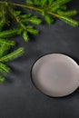 Empty Gray Plate with Black Border and Green Branches of Christmas Tree on Dark Gray Background Royalty Free Stock Photo