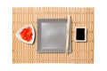 Empty gray square plate with chopsticks for sushi, ginger and soy sauce on yellow bamboo mat background. Top view with copy space Royalty Free Stock Photo