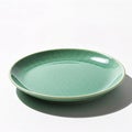 Empty green ceramic plate isolated on white background with shadow from the sun Royalty Free Stock Photo