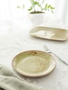 Empty green dinner plate with tablecloth on white marble table