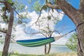 Lakeside hammock hanging between trees sunny day