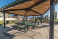 Empty green tables and benches in an urban park