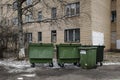 Empty green trash containers with brick wall of a building in background. Russia. Royalty Free Stock Photo