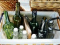 Empty green and White color glass bottles ready for bottling wine arranged in wicker baskets