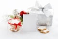 Empty greeting card and christmas gift box in silver wrapping paper over a white fluffy background. A jar full of star cookies. C