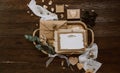 Empty greeting card with kraft envelope and gold decorations on wooden background. Wedding concept.