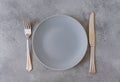 1 empty grey plate, fork, knife on grey concrete background, top view Royalty Free Stock Photo