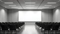 Empty hall with black seats before blank screen. Room is illuminated with lights on ceiling. Interior is ideal for presentations, Royalty Free Stock Photo