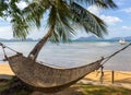 Empty hammock with palm tree and boat on tropical beach. Philippines resort landscape. Idyllic vacation concept. Royalty Free Stock Photo