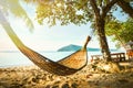 Empty hammock between palm trees on tropical beach. Paradise Island for holidays and relaxation. Royalty Free Stock Photo