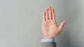 Empty hand palm in businessman grey suit on grey background