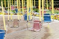 Empty hanging seats of a children's carousel in an amusement park. Selective focus. Royalty Free Stock Photo