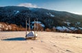 Empty haystack shed on snowy hillside