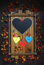 Empty heart blackboard on wood. Valentine\'s day concept. Dark background with colorful dry rose petals. Royalty Free Stock Photo