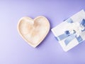 Empty heart shaped dish and gift box on purple. Greeting card