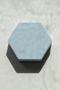 Empty hexagon pastel light blue platform podium on white background with natural light and shadows. Mock up background