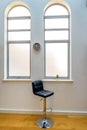 Empty high chair next to cactus in flower pot in a bright window and clock on wall Royalty Free Stock Photo