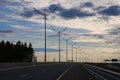 Empty highway against evening sky, row of light pillars, Royalty Free Stock Photo