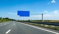 Empty Highway with Blue Blank Sign Under Sunny Sky Royalty Free Stock Photo