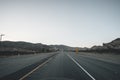 Empty Highway in California Right after Sunset with Yellow Road Sign and Mountains in the distance during Coronavirus Royalty Free Stock Photo