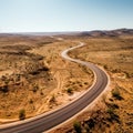 An empty highway is captured from a top-down perspective, offering an aerial view of the great landscape it traverses