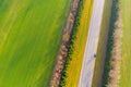 Highway going along green farmlands. Aerial view