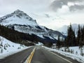 An empty highway on a snowy winter landscape going through the rocky mountains on a nice winter day in jasper national park Royalty Free Stock Photo