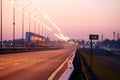 Empty highway stretching into the distance at sunrise