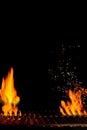 Empty hot barbecue BBQ grill with bright burning fire and sparks, smoldering coal on black background. Close up, copy