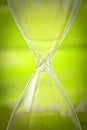 Empty hourglass on green background