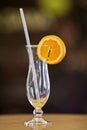 Empty hurricane glass with remains of orange juice