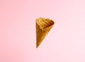 Empty ice cream waffle cup levitates on pink background Royalty Free Stock Photo
