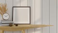 Empty image poster frame mockup on a wooden table with decor over the white plank wall Royalty Free Stock Photo