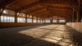 Empty indoor horse riding arena with sandy floor and sunlight through windows calm equestrian hall, AI generated Royalty Free Stock Photo