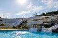 Empty water park with high white slides, pools and white sun loungers Royalty Free Stock Photo