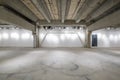 Empty interior of large concrete room as warehouse or hangar with spotlights Royalty Free Stock Photo